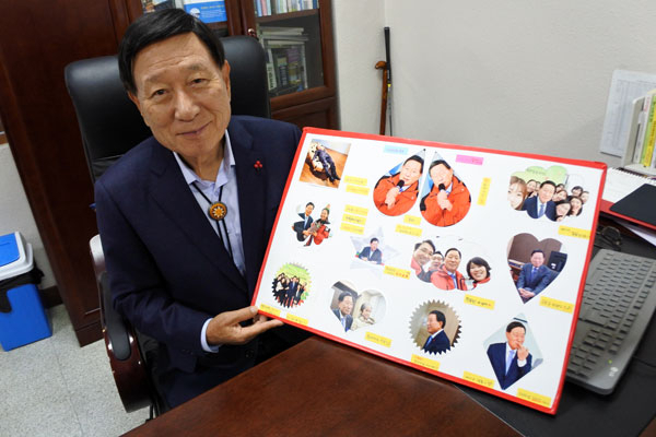 경북사회복지공동모금회 제9대 회장으로 연임된 신현수 회장이 경북모금회 직원들에게 받은 축하 메시지 판을 들어 보이고 있다. 신 회장은 