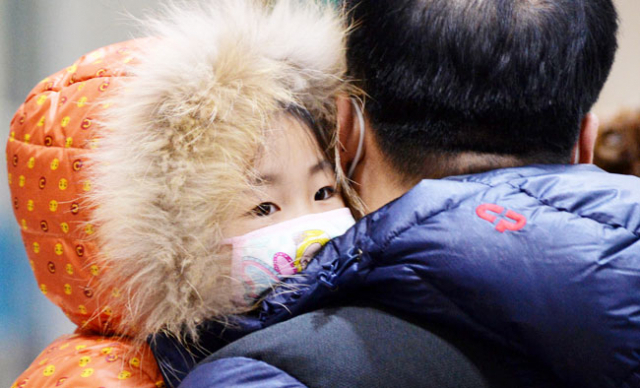 지진 피해를 입은 포항 지역에 매서운 추위가 찾아온 18일 오후 포항 흥해실내체육관에서 두꺼운 외투와 마스크를 쓴 어린이가 아빠 품에 꼭 안겨 있다. 김영진 기자 kyjmaeil@msnet.co.kr