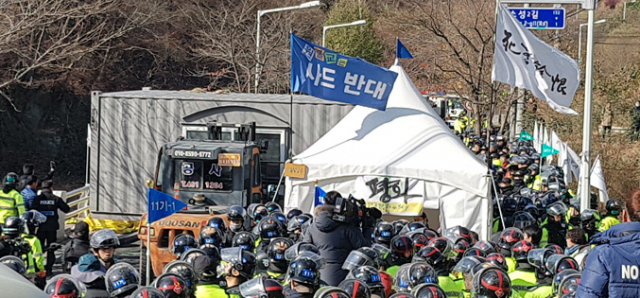 사드 배치 반대 측이 공사 차량과 장비 반입을 막기 위해 사드 기지 입구 진밭교에 설치한 컨테이너를 경찰이 지게차를 동원해 철거하고 있다. 이영욱 기자