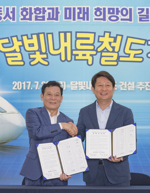 지난 7월 20일 권영진(오른쪽) 대구시장과 윤장현 광주시장이 달빛내륙철도 건설 조기 실현을 위한 공동선언문 서명을 마치고 악수하고 있다.