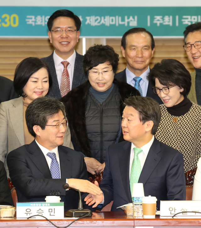 유승민(왼쪽) 바른정당 대표와 안철수 국민의당 대표가 23일 국회에서 열린 국민통합포럼 조찬 세미나에서 기념촬영 전 악수하고 있다. 연합뉴스
