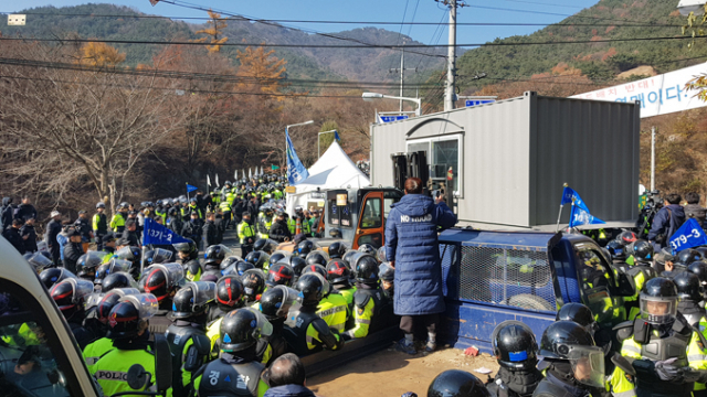 지난 21일 공사 장비와 자재를 실은 차량의 사드 기지 진입을 막기 위해 사드 배치 반대 측이 성주군 초전면 소성리 진밭교 위에 설치한 컨테이너가 지게차에 의해 힘없이 들려 나가자 사드 반대 관계자가 항의와 함께 망연자실 쳐다보고 있다. 이영욱 기자
