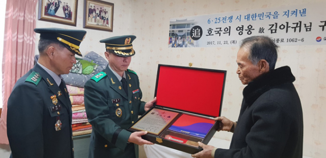 국방부 유해발굴감식단장 이학기 대령이 유가족(아들 김학모 씨)에게 유품과 위로패 등이 담긴 