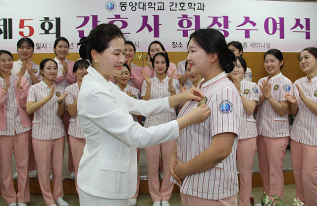 동양대 졸업생 간호사 휘장 수여식에서 이상미 간호학과장이 우세빈 학생에게 휘장을 달아주고 있다. 동양대 제공