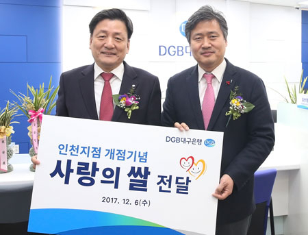 6일 열린 DGB대구은행 인천 1호점 개점식에서 성무용(왼쪽) 부행장이 인천시 강범석 서구청장에게 사랑의 쌀을 전달했다. DGB 대구은행 제공