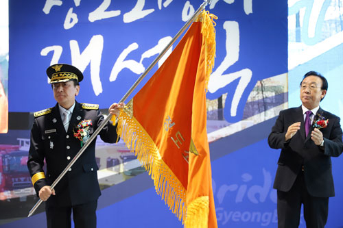 지난 8일 열린 청도소방서 개서식에서 김관용 경북도지사가 장인기 청도소방서장에게 서기를 전달한 뒤 박수를 치고 있다. 청도소방서 제공