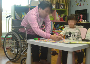 희귀난치성 근육병을 앓고 있는 이진홍(51) 씨가 발달장애를 겪고 있는 딸 지언(3) 양과 색칠공부를 함께하며 발달을 돕고 있다. 성일권 기자
