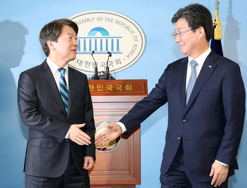바른정당 유승민(오른쪽) 대표와 국민의당 안철수 대표가 18일 오전 국회 정론관에서 열린 기자회견에서 통합 공동선언을 발표한 뒤 악수하고 있다. 연합뉴스