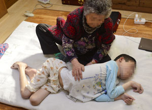 난치난치성 근육병으로 투병 중인 박정훈 씨를 할머니 이점순 씨가 돌보고 있다. 박 씨가 양손 엄지와 검지 정도만 움직일 수 있어 허리가 불편한 할머니는 간병하는 데 힘에 부친다. 성일권 기자 sungig@msnet.co.kr