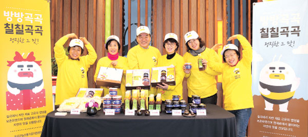 칠칠곡곡협동조합 회원들이 조합에서 생산하고 있는 쌀떡국, 쌀조청, 아로니아잼, 동결 아로니아 분말 등 농산물가공품들을 들어보이고 있다. 칠곡군 제공