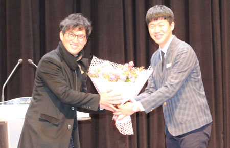 개그맨 고명환(왼쪽)이 모교 상주고 학생들에게 특강을 한 뒤 재학생 대표로부터 꽃다발을 받고 있다. 상주고 제공