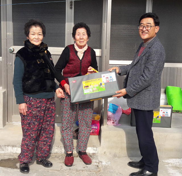 김필규(오른쪽) ㈜장진플라테크 대표가 12일 칠곡군 기산면 죽전2리의 소계준(가운데) 할머니 댁을 찾아 설 선물을 전달하고 있다.