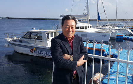 박경조 경북요트협회장이 울진군 후포항 요트학교 계류장에서 환한 웃음을 짓고 있다.