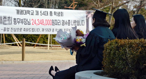 20일 대구시내 한 대학교에서 학위수여식을 마친 졸업생들이 바닥에 앉아 이야기를 나누고 있다. 졸업은 했지만 취업이 어려운 요즘 대학가 졸업식 풍경이 밝지만은 않다. 4년간 등록금 총액을 적은 졸업 축하 현수막이 눈길을 끈다. 우태욱 기자 woo@msnet.co.kr