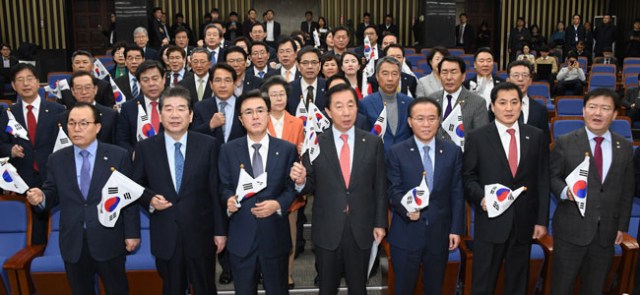 자유한국당 김성태 원내대표와 참석 의원들이 22일 오후 국회에서 열린 의원총회에서 태극기를 흔들며 김영철 북한 노동당 중앙위원회 부위원장 겸 통일전선부장의 평창동계올림픽 폐회식 참석을 반대하는 구호를 외치고 있다. 연합뉴스