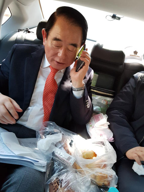 박명재 한국당 국회의원이 22일 낮 이동 차량에서 빵으로 점심을 해결하고 있다. 박 의원은 식사 중에도 휴대전화기를 놓지 않았다. 박명재 의원실 제공