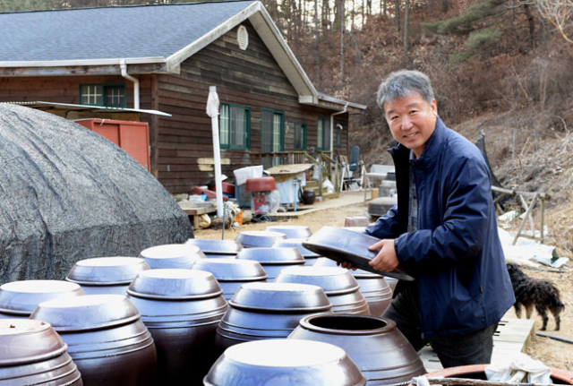 된장 독을 살펴보고 있는 심원복 이장. 된장