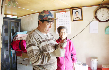맞춤형복지 사업의 하나로 재능기부에 나선 김경환 버드내 희망돋보기 위원이 홀몸노인 가구의 노후화된 전기시설을 손보고 있다. 윤영민 기자