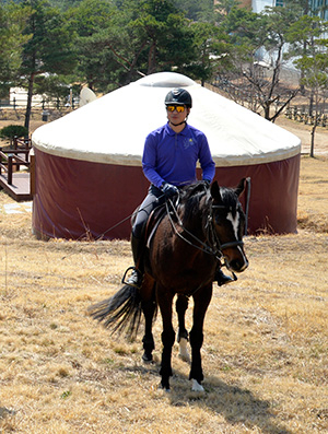 말을 탄 기수 뒤편으로 게르가 보인다. 운주산승마장에서는 4명 이상 1박 2일 승마체험을 예약하는 이들에게 무료로 숙박할 수 있는 게르를 빌려준다.