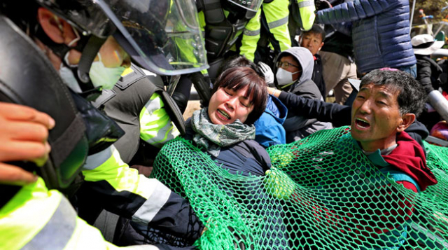 성주 사드 기지에 환경 개선 공사용 장비 투입이 시작된 12일 오전, 경찰이 성주 초전면 진밭교에서 몸에 그물을 두르고 진입을 막고 있던 사드 반대 단체와 주민들을 강제 해산시키고 있다. 사드 반대 주민들은 국방부의 대화 끝에 트레일러로 사드 기지 안에 있는 공사 중장비를 반출하고 장비 반입 문제는 추후 논의하기로 하고 자진 해산했다. 김영진 기자 kyjmaeil@msnet.co.kr