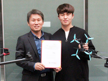 문윤배 수성대 드론기계과 교수가 드론레이싱 국가대표에 선발된 한동록(오른쪽) 군을 축하하고 있다. 수성대 제공