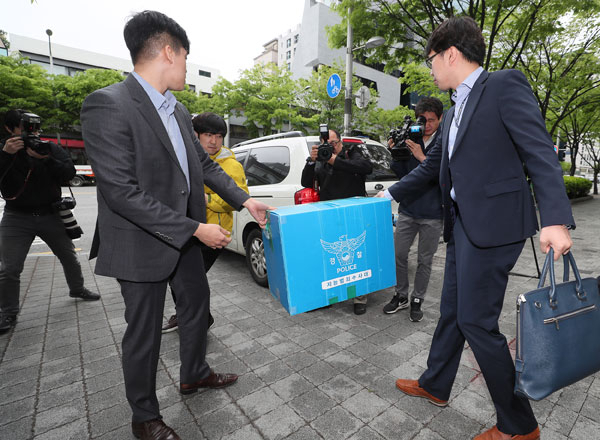 네이버 댓글 여론조작 사건을 수사하는 경찰 수사관들이 24일 느릅나무 출판사 세무 업무를 담당한 서울 강남구 한 회계법인에서 압수수색을 마친 뒤 압수 물품을 들고 나오고 있다. 연합뉴스