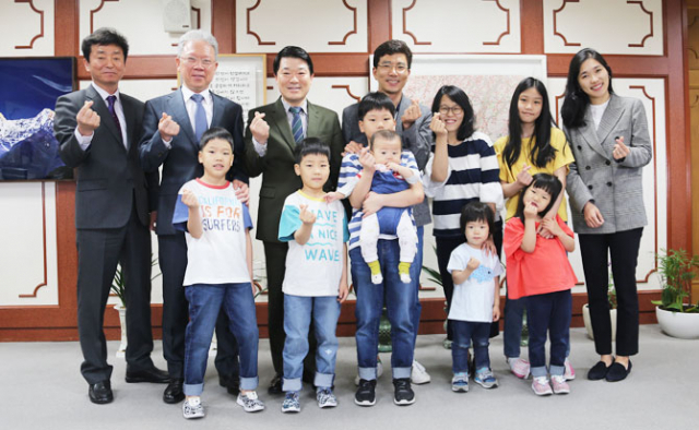 7남매 다둥이 가족이 9일 김찬돈 대구지방법원장의 초대를 받아 대구지법을 찾았다. 왼쪽부터 고영삼 대구지법 사무국장, 강동명 수석부장판사, 김찬돈 지법원장, 다둥이네 아빠 최재호 씨, 엄마 공채송 씨, 첫째 하은(13) 양, 이혜랑 공보판사이다. 아래쪽은 왼쪽부터 셋째 요한(9) 군, 넷째 모세(8) 군, 둘째 다윗(11) 군, 여섯째 요셉(4) 군, 다섯째 하영(6) 양이다. 다윗 군이 안고 있는 아이가 지난해 11월 태어난 하늘이다. 대구지법 제공