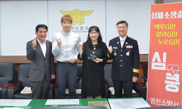영천소방서가 30일 심폐소생술로 시민을 살린 영천 영화초등학교 보건교사 서진희 씨와 학부모 윤동구 씨에게 표창패를 수여했다. 영천소방서 제공