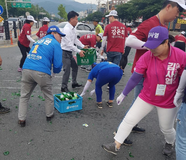 4일 오전 대구 수성구 두산오거리에서 일어난 교통사고 현장에서 선거운동원들이 합심해 깨진 소주병을 치우고 있다. 독자 제공.