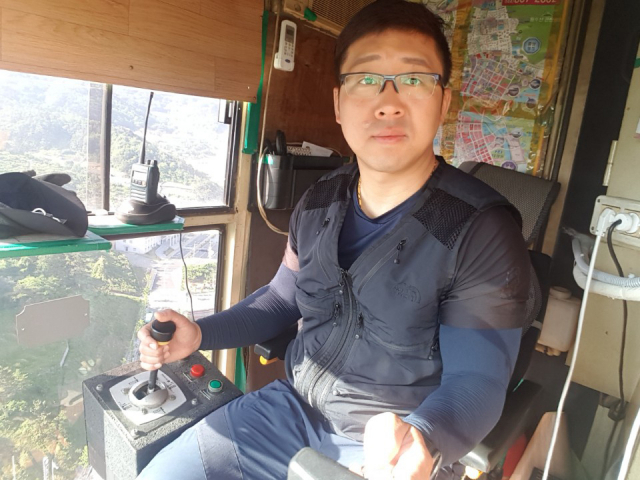 높은 상공에서 타워크레인을 조종하는 기사들은 일당백의 작업을 수행하는 건설현장의 꽃이다. 하지만 죽음에 대한 공포도 상존해 불안 속에 살고 있다. 타워크레인을 조종하는 김주한 씨.