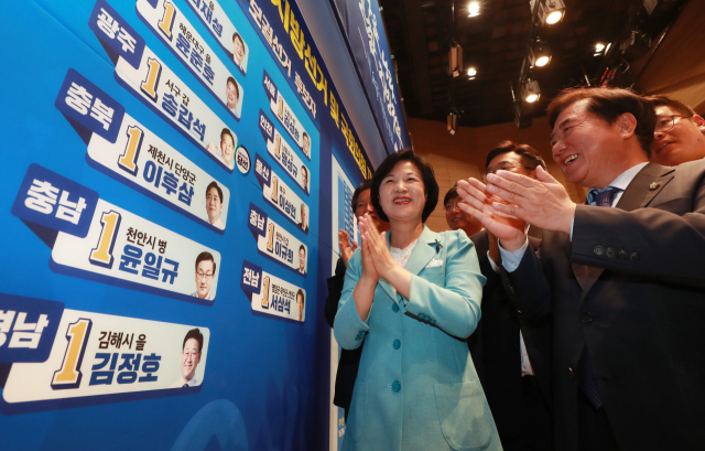 더불어민주당 추미애 대표가 13일 저녁 국회 의원회관에 마련된 선거상황실을 찾아 선거개표종합상황판에 광역단체장 당선 스티커를 붙이고 있다. 연합뉴스