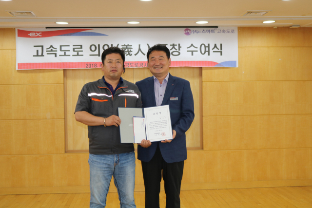 김시환 한국도로공사 부산경남본부장이 박세훈 씨(사진 왼쪽)에게 고속도로 의인상 표창장과 포상금을 수여하고 기념촬영을 하고 있다. 한국도로공사 제공