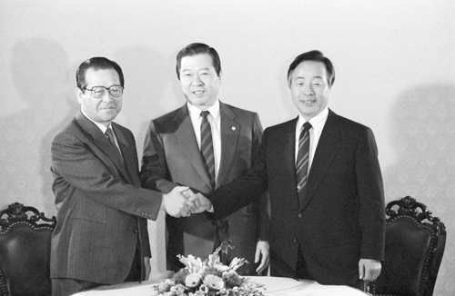 1989년 당시 민주당 김영삼 총재(오른쪽), 평민당 김대중 총재(가운데), 공화당 김종필 총재가 여권의 중간평가 조기강행 대책을 논의하기에 앞서 악수하는 모습. 2018.6.23 [연합뉴스 자료사진] 연합뉴스