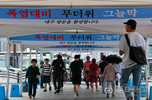지난 12일 찜통 더위 속에 대구의 관문인 동대구역 출입구부터 버스정류장까지 그늘막 텐트가 설치돼 시민들이 더위를 피해 이동하고 있다. 이날 대구 낮 최고 기온은 34.4도를 기록했다. 대구기상지청은 당분간 비 소식 없이 35도를 웃도는 무더위가 이어질 것으로 전망했다. 우태욱 기자 woo@msnet.co.kr