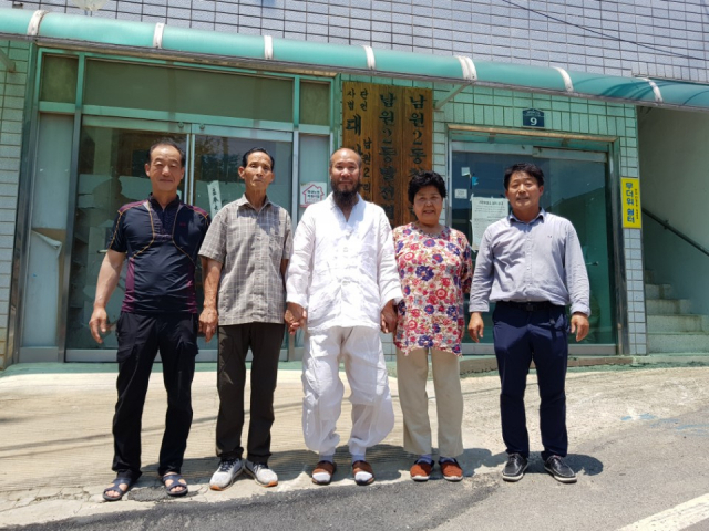 (왼쪽부터)김석배 새마을지도자와 이흥로 노인회장, 이찬우 남원2리 이장, 정점선 부녀회장, 조진식 남원2리 총무가 마을회관 앞에서 서로 손을 맞잡고 이 이장을 격려하고 있다. 조진식 남원2리 총무 제공