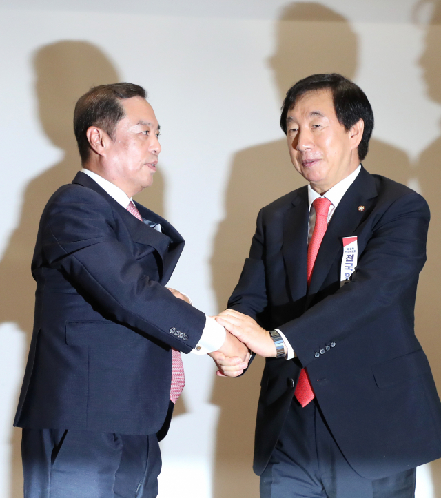 자유한국당 김병준 혁신비대위원장과 김성태 원내대표(오른쪽)가 17일 오전 국회 의원회관에서 열린 제2차 전국위원회에서 인사를 마치고 손잡고 있다. 연합뉴스