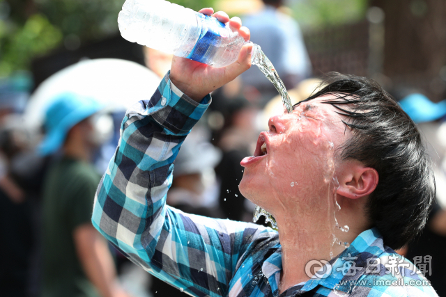 대구지역 낮 최고기온이 36.6℃를 기록한 17일 오후 달서구 신당동 주택가에서 한 시민이 달아오른 열기를 식히기 위해 얼음 물을 얼굴에 부으며 더위를 식히고 있다. 정운철 기자 woon@msnet.co.kr