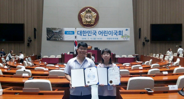 대구 감천초 어린이국회연구회 소속 정영주(오른쪽) 양이 김종렬 지도교사와 함께 받은 국회부의장상을 들어 보이고 있다. 감천초 제공