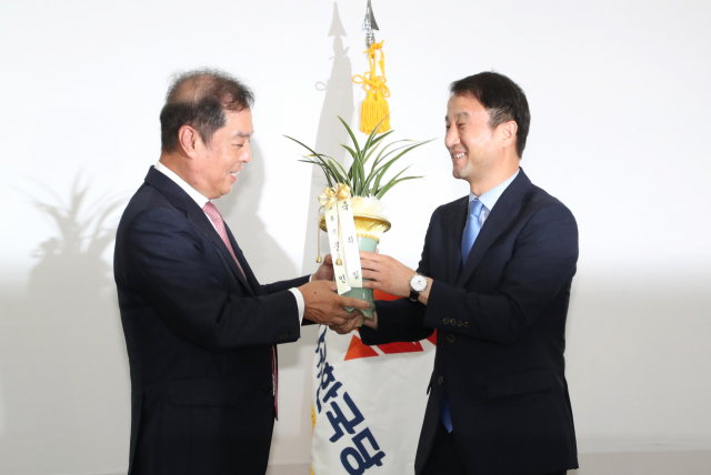 자유한국당 김병준 혁신비상대책위원장(왼쪽)이 19일 오전 국회에서 인사차 방문한 한병도 청와대 정무수석으로부터 난을 전달받고 있다. 연합뉴스