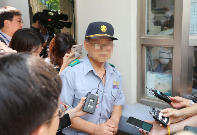 23일 오전 정의당 노회찬 원내대표가 투신 사망한 것으로 알려진 서울 중구 한 아파트에서 노 원내대표를 처음 발견해 경찰에 신고한 경비원이 취재진의 질문에 답하고 있다. 연합뉴스