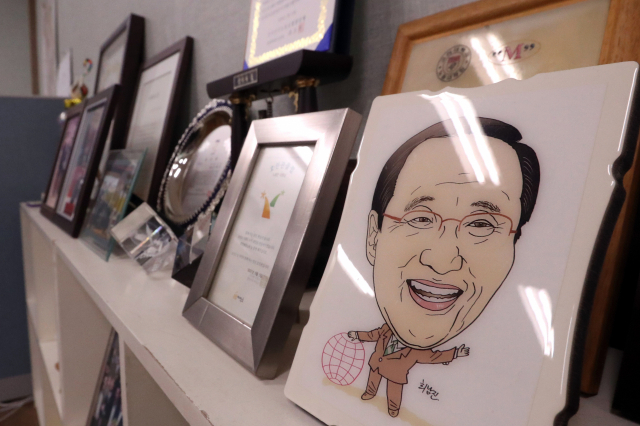 정의당 노회찬 원내대표가 서울 한 아파트에서 투신해 사망한 23일 오전 경남 창원시 노회찬 의원 지역사무실 내 노 의원의 상패와 캐리커처 등이 걸려 있다. 연합뉴스