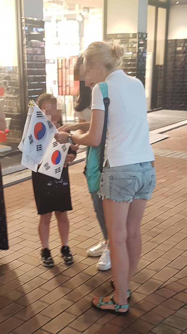 지난 21일 오후 8시30분쯤 대구 동성로 대구백화점 앞 광장 인근에서 한 외국인 여성이 시민에게 태극기를 팔고있다. 가벼운 옷차림이지만 이 여성은 스스로를 무전여행자라고 밝히고 여행경비 마련에 동참해달라는 쪽지를 들고 다니며 태극기를 팔고 있었다. 이주형 기자