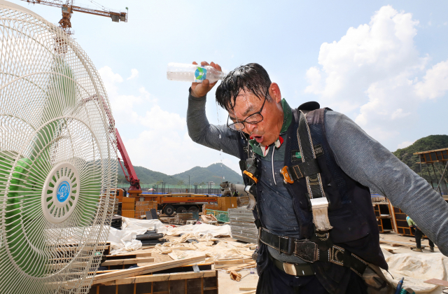 폭염과 전쟁을 치르는 대구 연경지구 건설현장 근로자가 26일 동구 지묘동 아파트 신축공사장에서 머리에 물을 부으며 몸의 열기를 식히고 있다. 정운철 기자 woon@msnet.co.kr