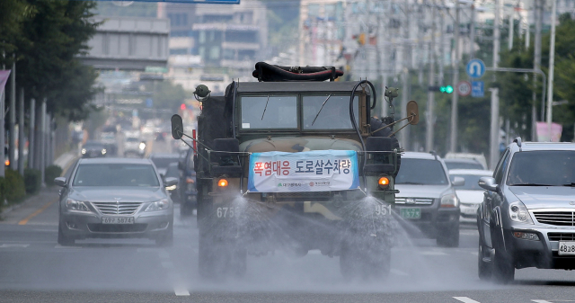 지난달 24일 오후 육군 50사단 화학 제독차량이 대구 칠곡 3지구 도로변에 살수작업을 하며 열기를 식히고 있다. 매일신문DB