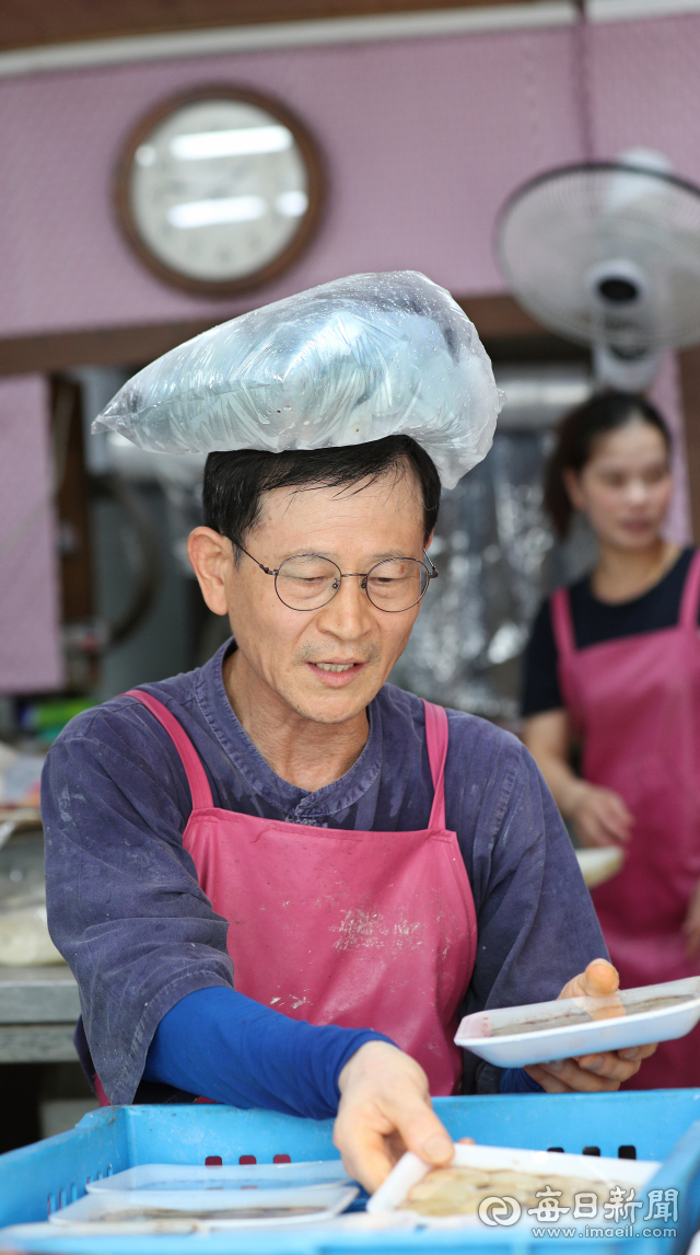 영천시 신녕면 낮 최고기온이 40.6℃, 의성 40.4도, 대구 37.5도를 기록한 1일 오후 남구 봉덕시장의 한 떡집 가게에서 주인 이관재(60)씨가 폭염으로 머리에서 열이 나자 얼음이 가득 담긴 주머니를 머리에 얹힌 채 장사를 하고 있다. 정운철 기자 woon@msnet.co.kr