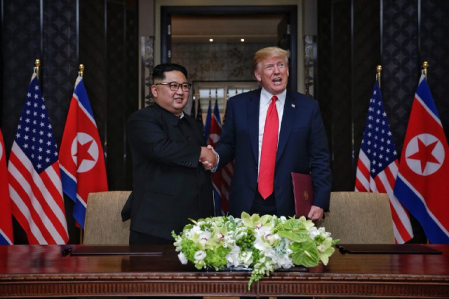 사진은 지난 6월 12일 싱가포르 센토사 섬 카펠라호텔에서 열린 북미정상회담에서 북한 김정은 국무위원장과 미국 도널드 트럼프 대통령이 공동합의문에 서명을 마친 뒤 악수하는 모습. 연합뉴스