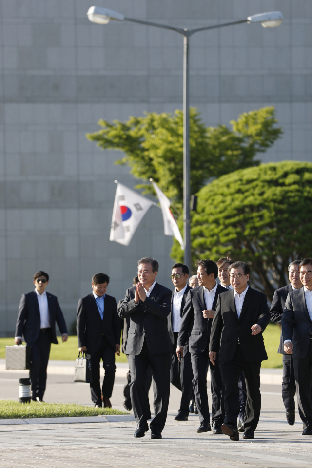 문재인 대통령이 20일 오후 서울 서초구 내곡동 국가정보원을 찾아 서훈 국정원장의 안내로 국정원 청사 경내를 둘러 보다 직원들에게 인사하고 있다. 연합뉴스