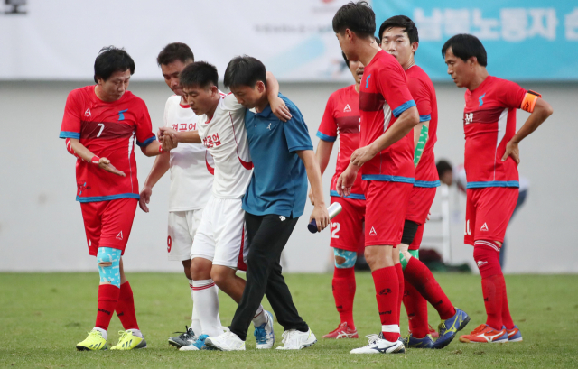 11일 오후 서울월드컵경기장에서 열린 남북노동자통일 축구대회 민주노총 대표팀과 북측 조선직업총동맹 경공업팀의 경기. 북한 경공업 김철성이 근육통증을 호소하자 민주노총 이상오가 부축을 해주고 있다. 연합뉴스