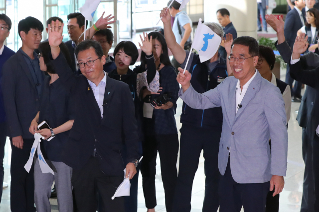 12일 오후 경기도 파주시 경의선 남북출입사무소에서 김명환 민주노총 위원장(앞줄 왼쪽)과 김주영 한국노총 위원장(앞줄 오른쪽)이 출경하는 북측 선수단원들을 향해 손을 흔들고 있다. 연합뉴스