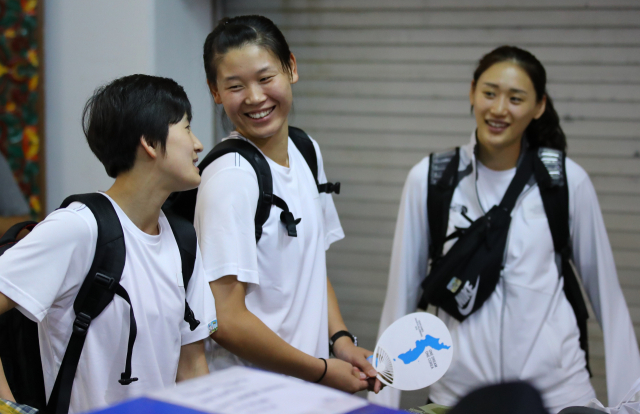 2018 자카르타-팔렘방 아시안게임에 출전하는 여자농구 남북 단일팀의 강이슬(오른쪽)과 북측 선수인 로숙영(가운데), 김혜연이 13일 밤 결전지인 자카르타 수카르노-하타 국제공항에 도착해 대화를 나누며 활짝 웃고 있다. 연합뉴스